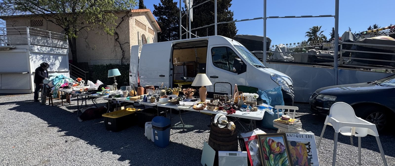 A brocante at dawn in autumn, dealers in jackets, first light on the tables.